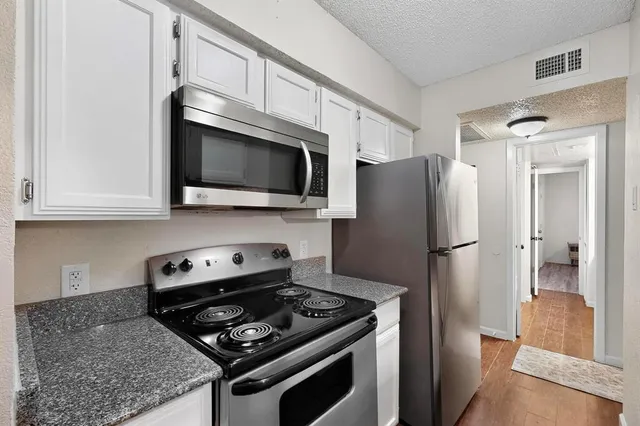 a kitchen with stainless steel appliances granite countertop a refrigerator stove and microwave