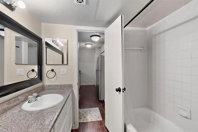 a bathroom with a granite countertop sink shower mirror and toilet