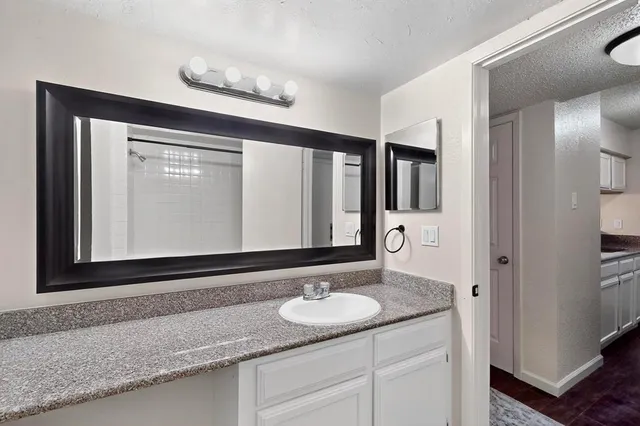 a bathroom with a granite countertop sink and a mirror