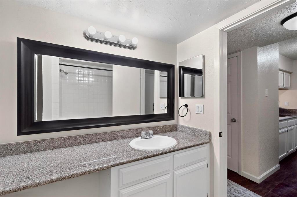 9611 Walnut Street, Unit 1105 Dallas, TX 75081 - Photo 16 of 24 a bathroom with a granite countertop sink and a mirror