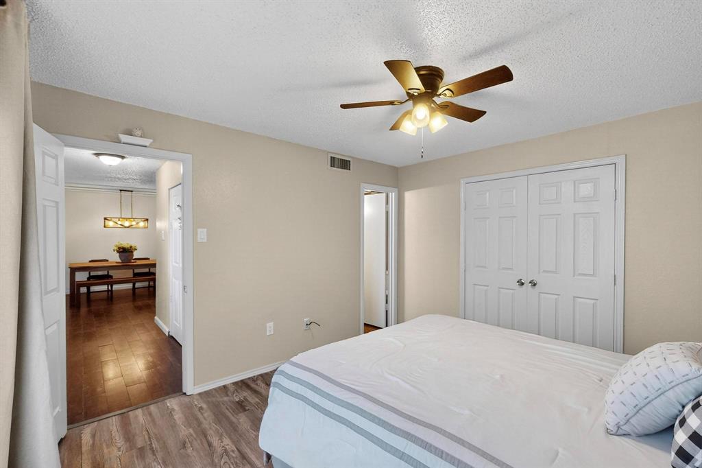 9611 Walnut Street, Unit 1105 Dallas, TX 75081 - Photo 19 of 24 a bedroom with a bed and a chandelier