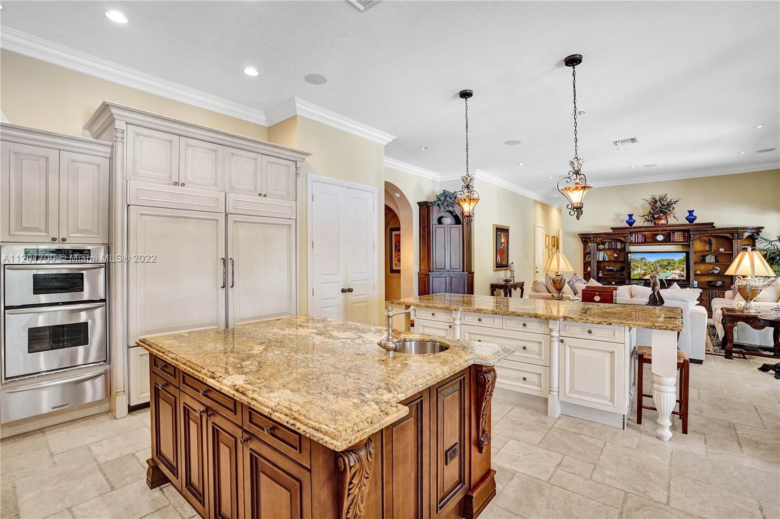 3460 Paddock Road Weston, FL 33331 - Photo 21 of 62 a kitchen with kitchen island granite countertop a table chairs sink and cabinets