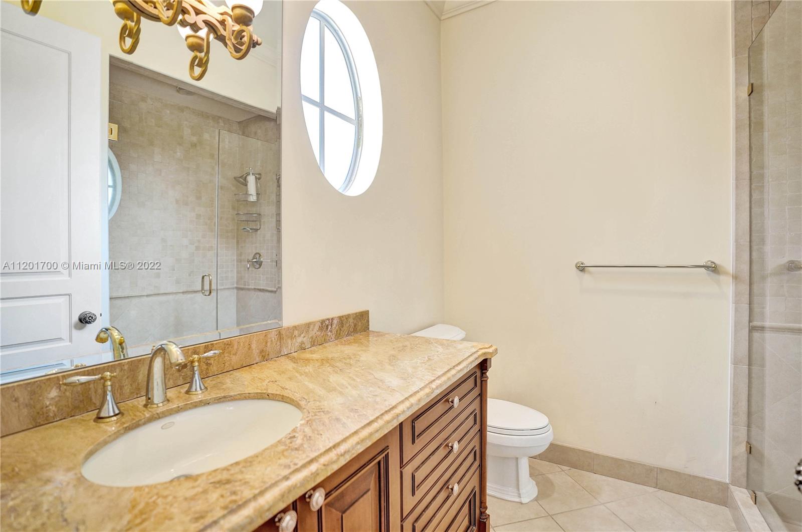 3460 Paddock Road Weston, FL 33331 - Photo 38 of 62 a bathroom with a granite countertop sink a toilet and a mirror
