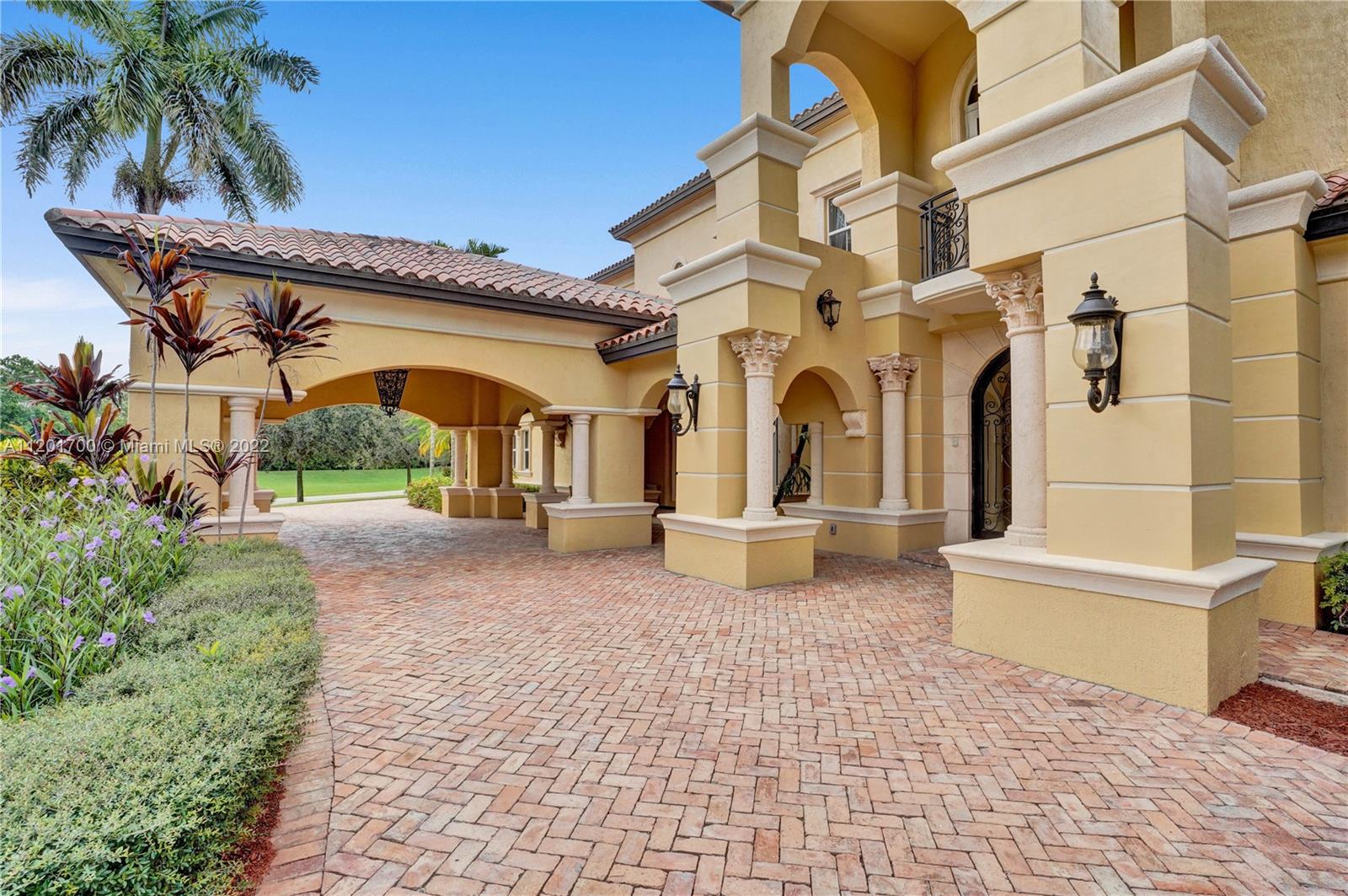 3460 Paddock Road Weston, FL 33331 - Photo 5 of 62 a front view of a building with garden and seating area