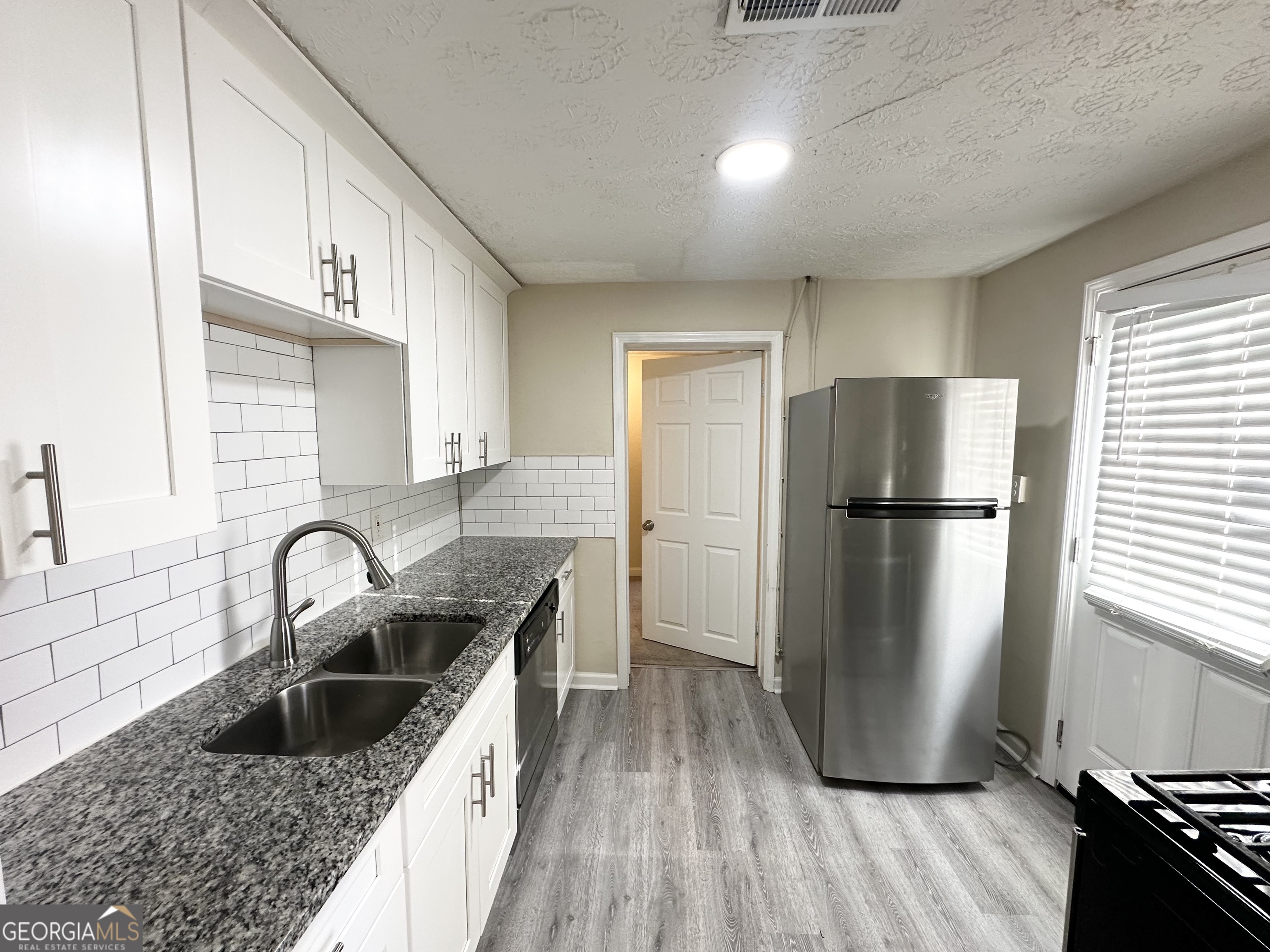 1876 Flat Shoals Road Southeast Atlanta, GA 30316 - Photo 5 of 11 a kitchen with granite countertop a refrigerator and a sink