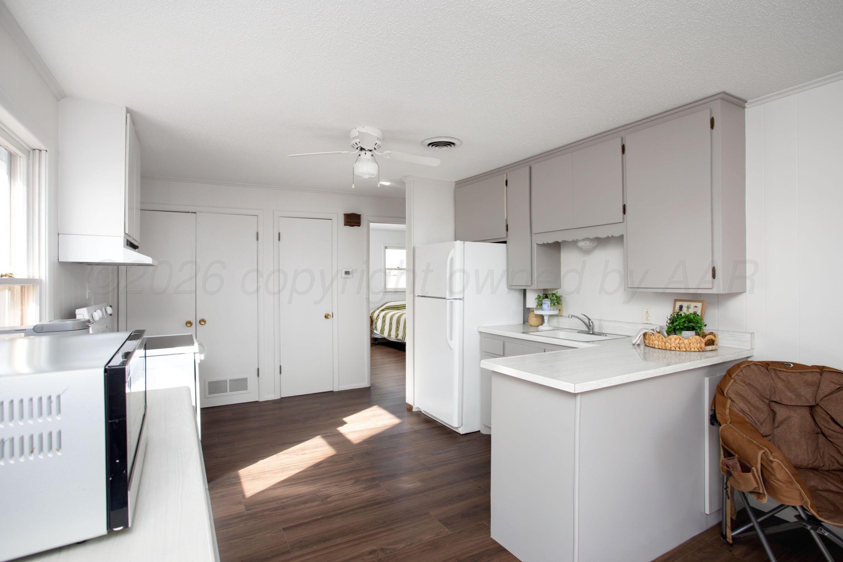 1107 Main Street Panhandle, TX 79068 - Photo 11 of 24 a kitchen with wooden cabinets and white appliances