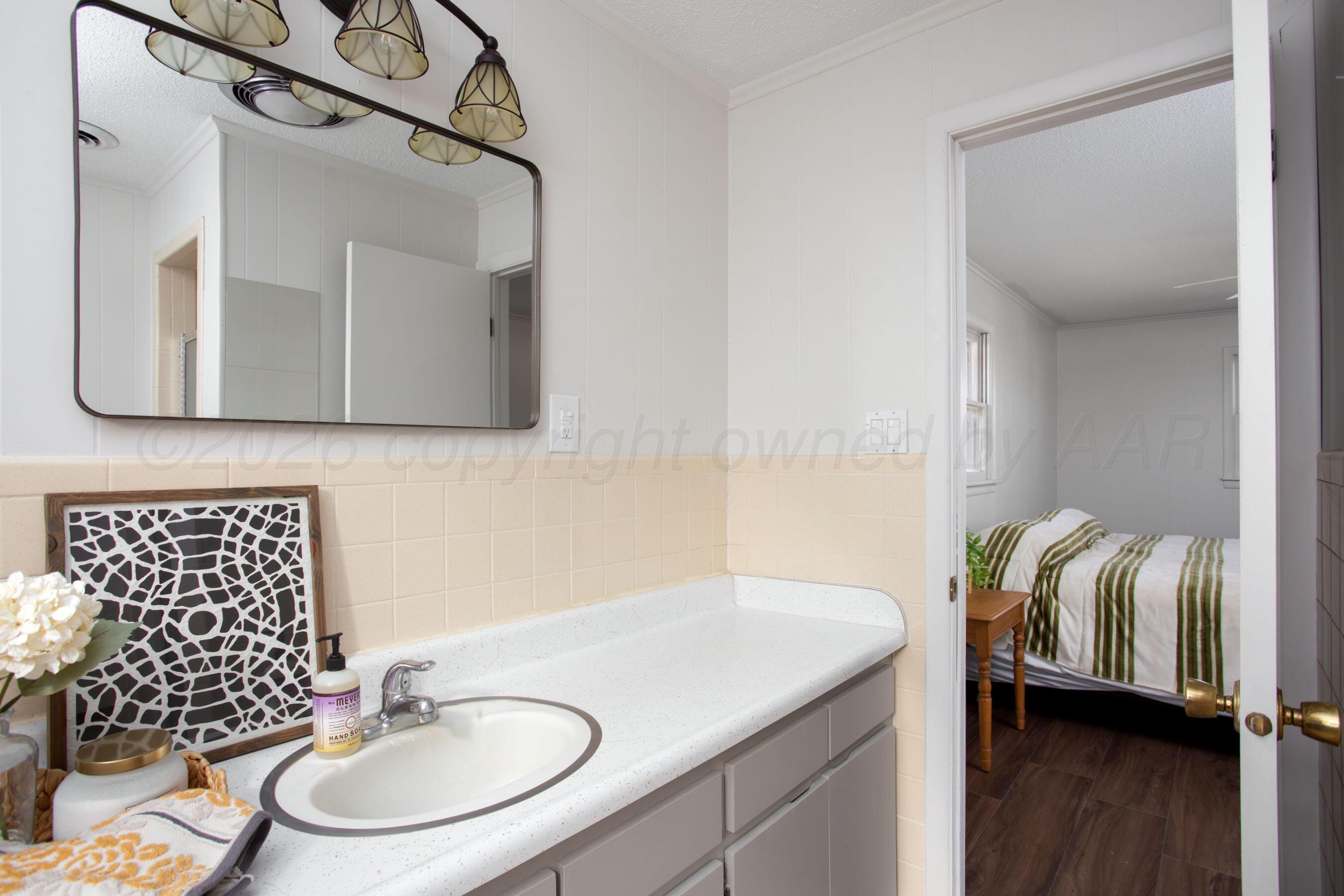 1107 Main Street Panhandle, TX 79068 - Photo 19 of 24 a bathroom with a sink and a mirror