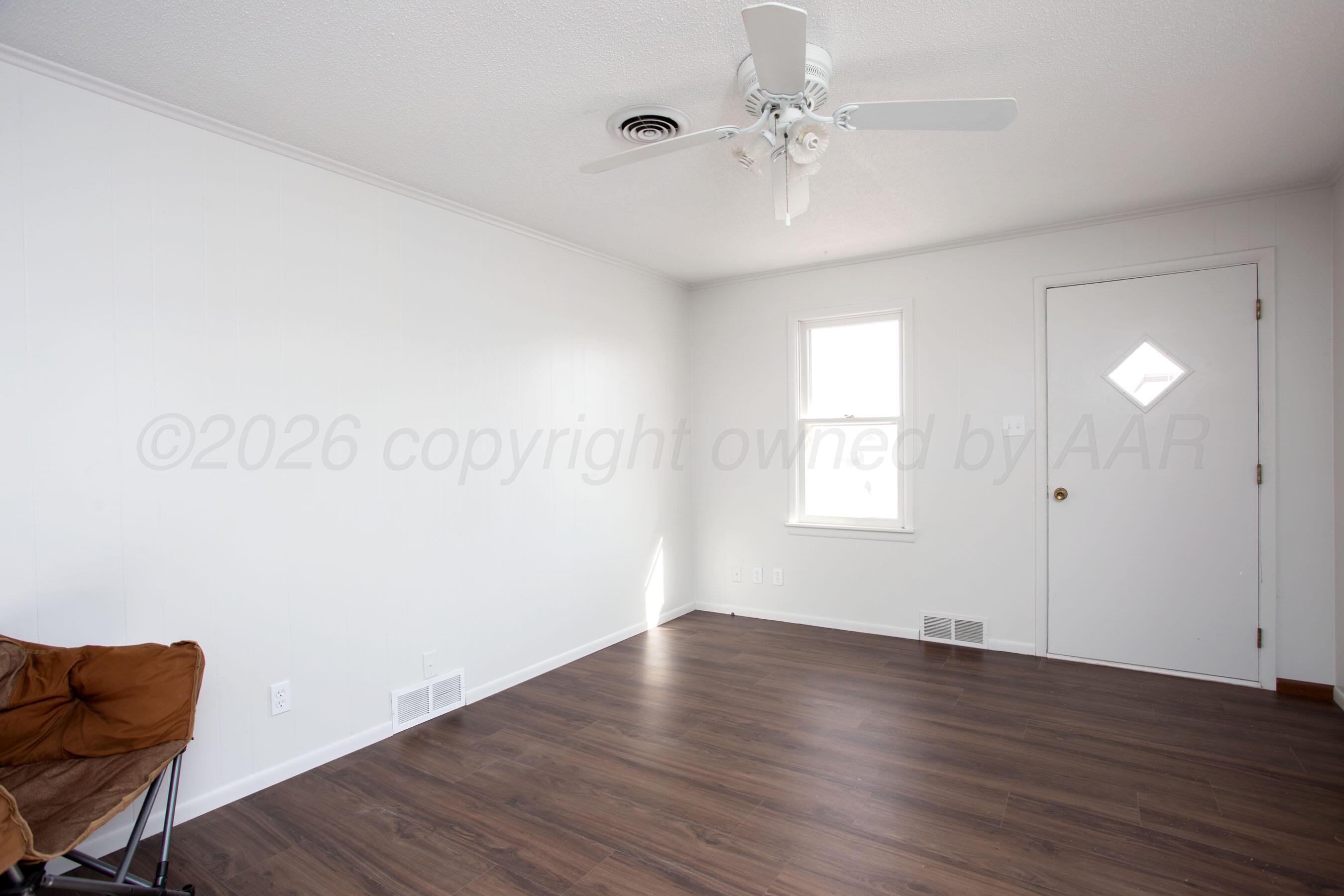 1107 Main Street Panhandle, TX 79068 - Photo 8 of 24 wooden floor in an empty room with a window