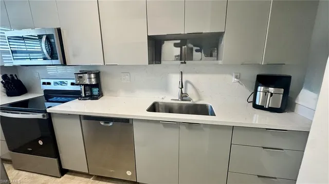 a kitchen with stainless steel appliances a sink a stove and cabinets