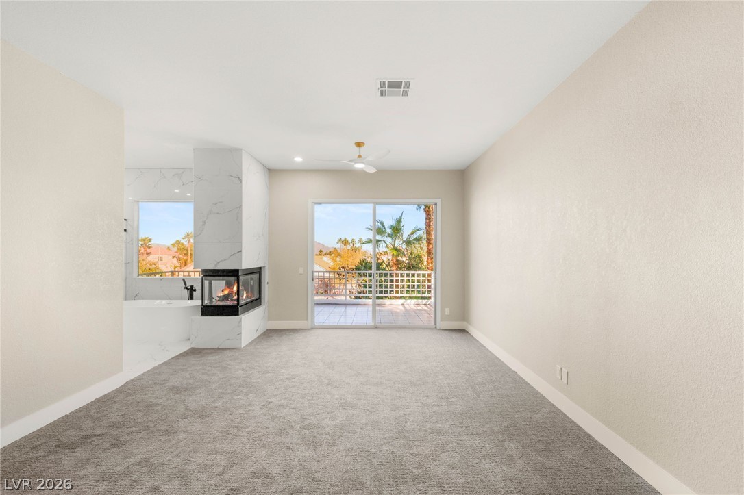 2104 Inverness Drive Henderson, NV 89074 - Photo 25 of 51 Unfurnished living room with a fireplace, plenty of natural light, carpet flooring, recessed lighting, and ceiling fan