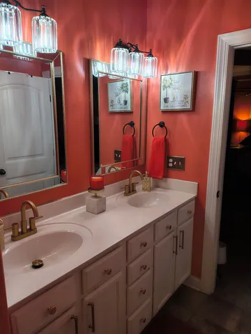 a bedroom with a bed and a dresser with mirror