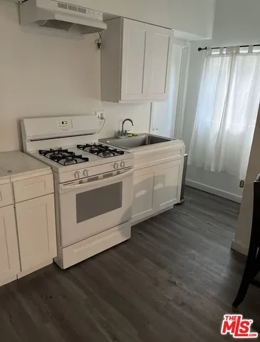 a kitchen with granite countertop white cabinets and white appliances