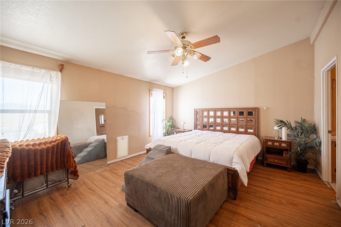 3200 Maple Road Pahrump, NV 89048 - Photo 32 of 53 A spacious sleeping quarter showcasing hardwood-style flooring and a sloped ceiling with a ceiling fan.