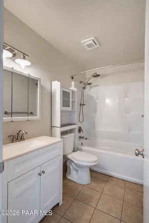 a bathroom with a double vanity sink a toilet a mirror and shower