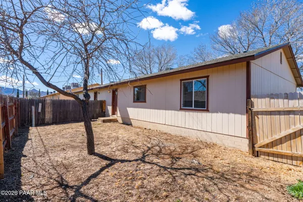 a view of backyard with wooden fence