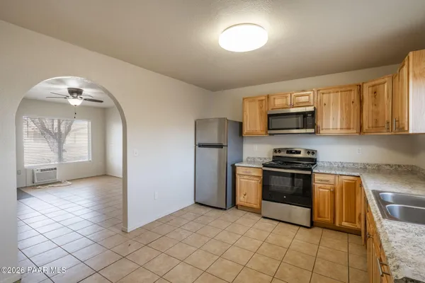 a kitchen with stainless steel appliances granite countertop a refrigerator and a stove top oven