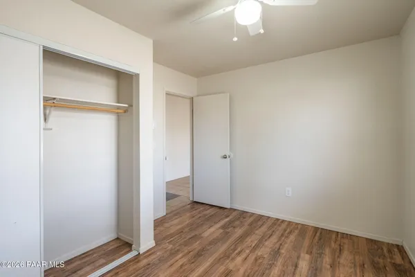 a view of an empty room with closet and a window