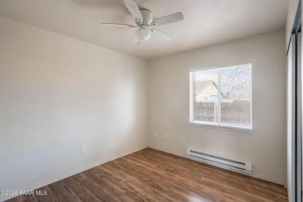 an empty room with windows and fan