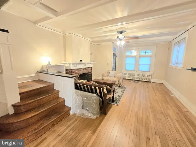 a view of a living room with wooden floor and furniture