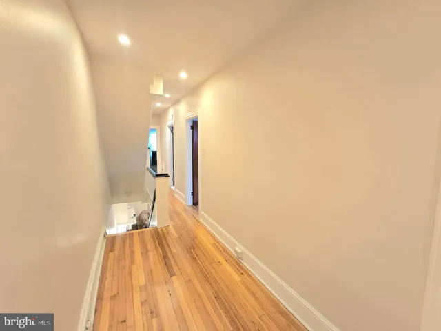 a view of a room with wooden floor and a ceiling fan