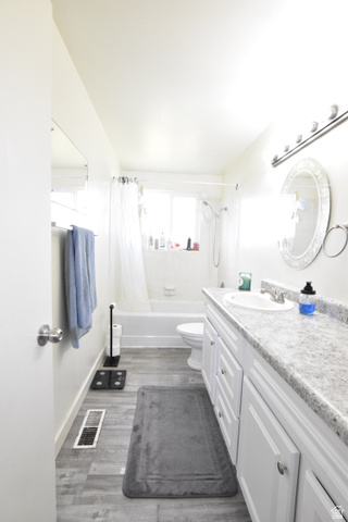 290 West 600 North Logan, UT 84321 - Photo 21 of 45 Bathroom featuring a white vanity with dual sinks, a speckled countertop, and white cabinetry