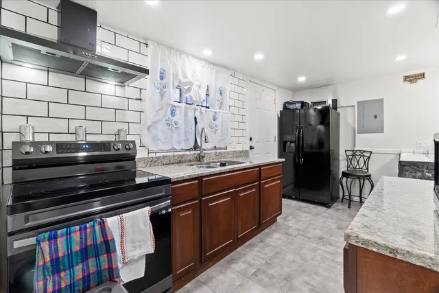 a kitchen with stainless steel appliances granite countertop a stove a sink and a refrigerator