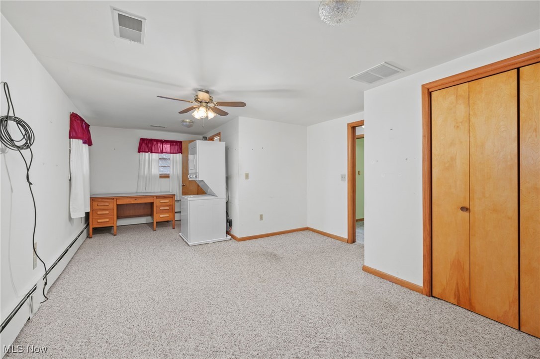 9952 Sterling Road Rittman, OH 44270 - Photo 12 of 28 Unfurnished bedroom featuring baseboard heating, light carpet, a desk, and ceiling fan
