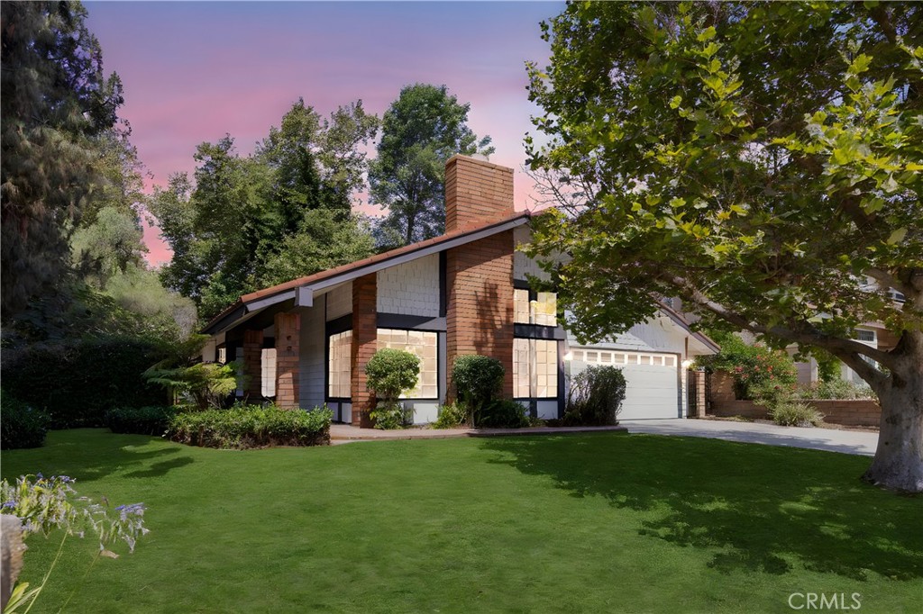 a front view of house with a garden