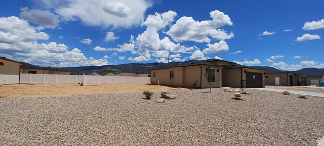4956 North 925 East, Unit 87 Enoch, UT 84721 - Photo 3 of 19 Contemporary single-story residence with a stucco exterior and dark shingle roof