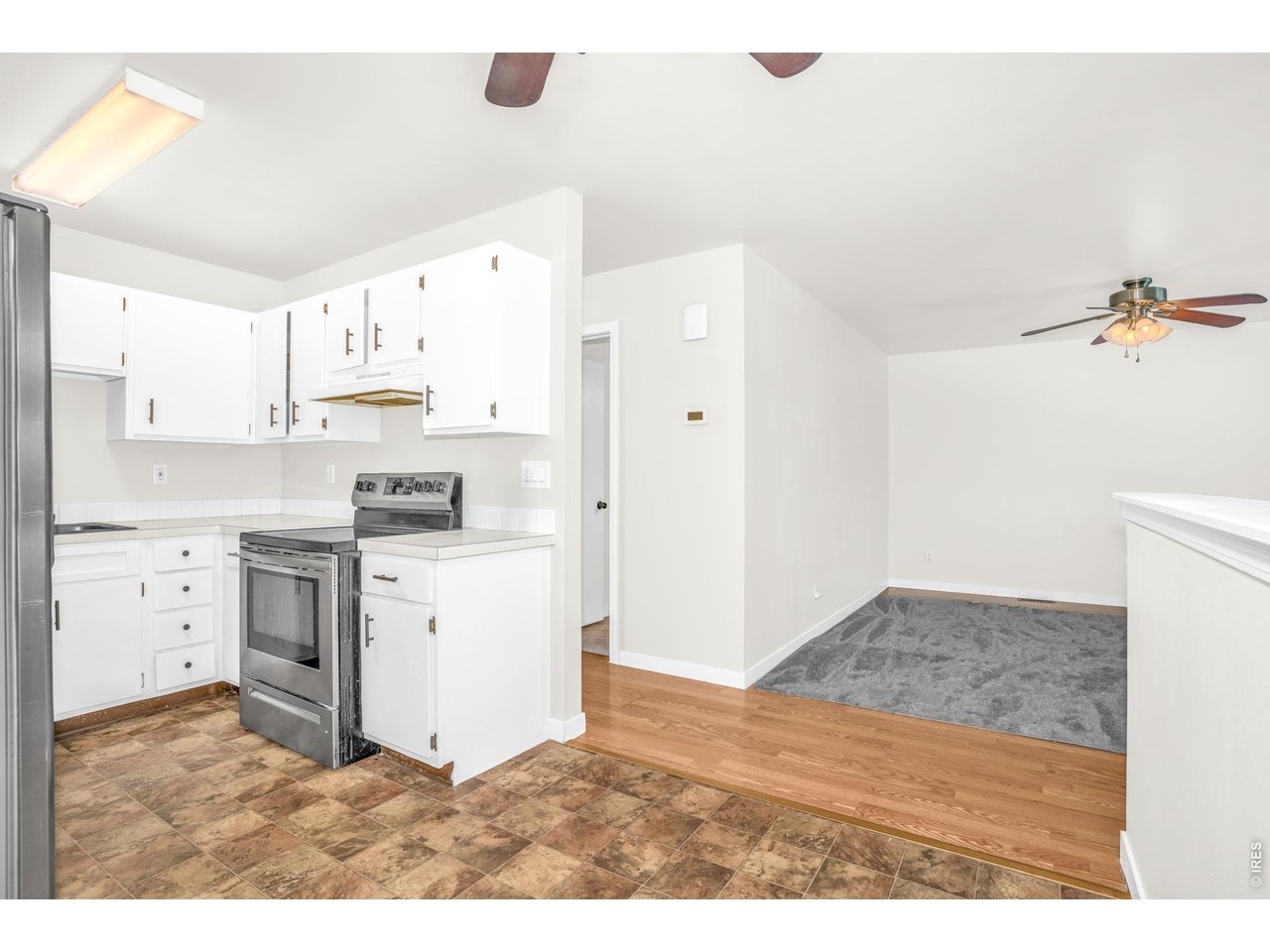 526 East 23rd Street Road Greeley, CO 80631 - Photo 10 of 20 a kitchen with white cabinets and appliances