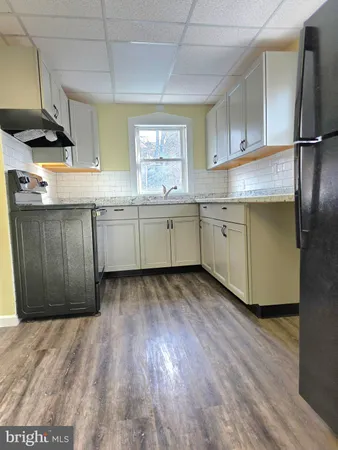 a kitchen with granite countertop cabinets stainless steel appliances a sink and a window