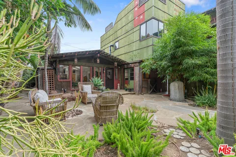 a view of the patio with couches and table and chairs under an umbrella