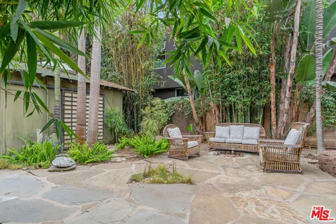 a view of backyard with outdoor seating and trees