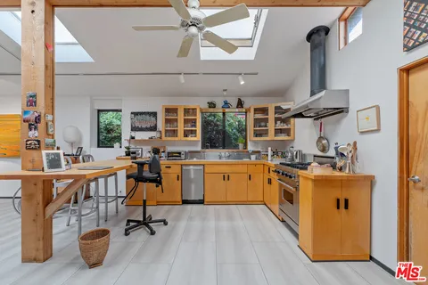 a kitchen with stainless steel appliances a stove a sink dishwasher and a refrigerator with wooden floor