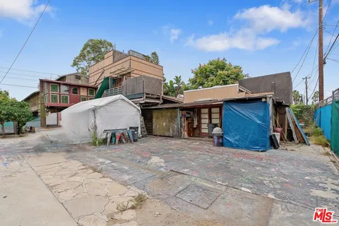 a view of a house with a yard and wooden fence