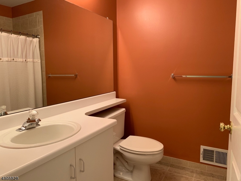 105 Well Sweep Road, Unit 105 Whitehouse Station, NJ 08889 - Photo 14 of 22 a bathroom with a sink and mirror with toilet
