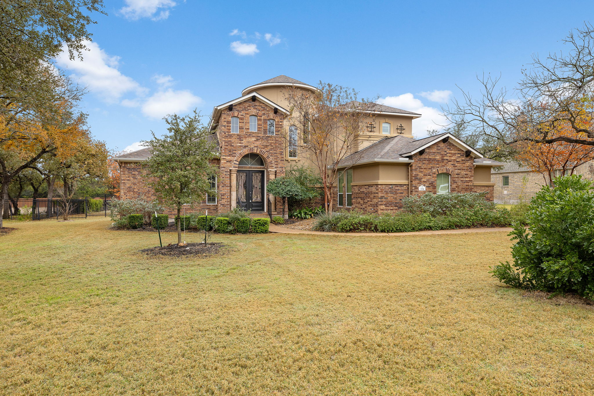 View of front facade with a front lawn, brick siding, and roof with shingles