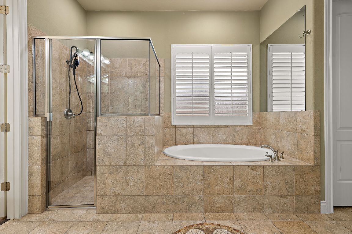 174 Estrella Crossing Georgetown, TX 78628 - Photo 19 of 39 Bathroom featuring a garden tub, a shower stall, and tile patterned floors