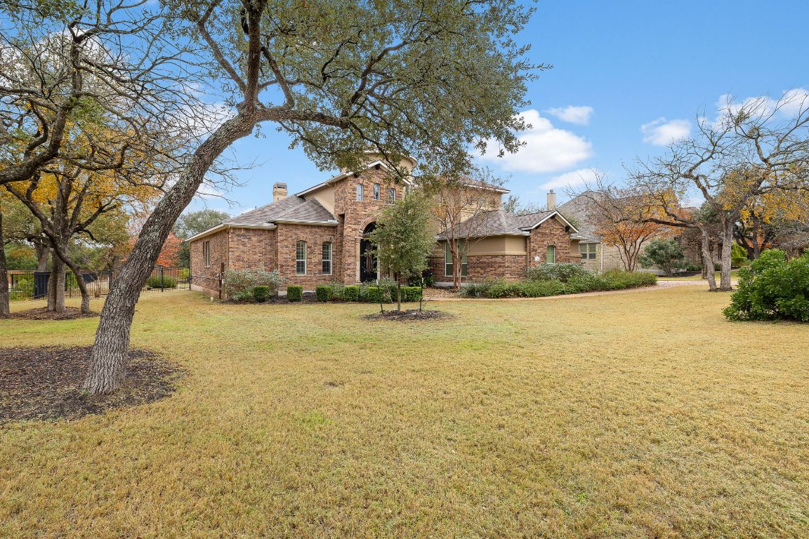 174 Estrella Crossing Georgetown, TX 78628 - Photo 2 of 39 Traditional home with a chimney, a front yard, and brick siding