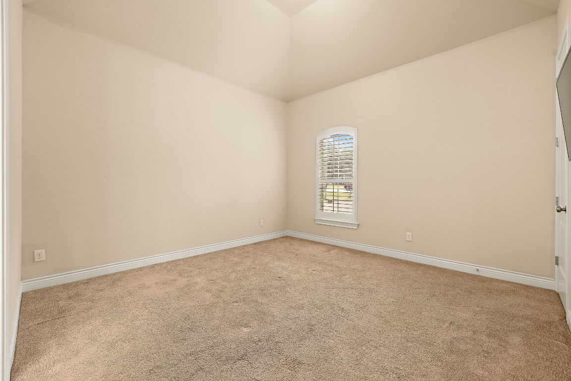 174 Estrella Crossing Georgetown, TX 78628 - Photo 22 of 39 Unfurnished room featuring light carpet and vaulted ceiling