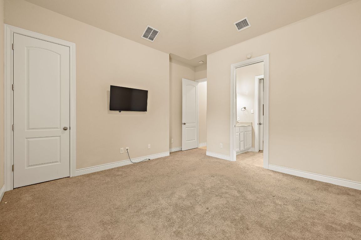 174 Estrella Crossing Georgetown, TX 78628 - Photo 23 of 39 Unfurnished bedroom with light carpet and ensuite bathroom