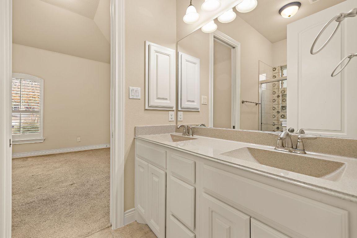 174 Estrella Crossing Georgetown, TX 78628 - Photo 24 of 39 Full bathroom featuring light colored carpet, double vanity, a stall shower, and lofted ceiling
