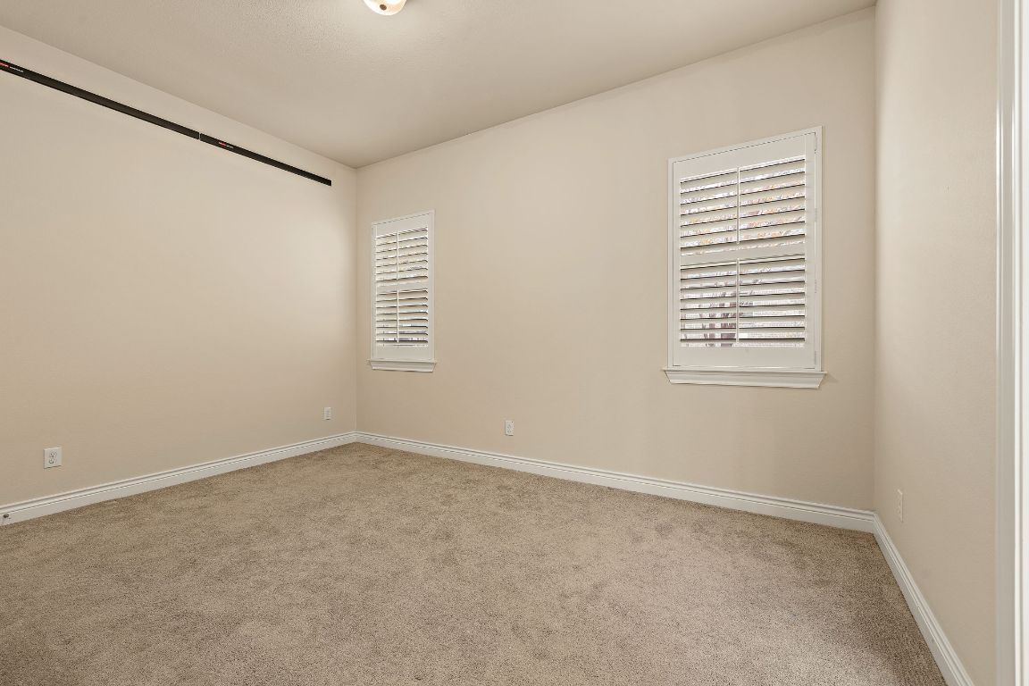 174 Estrella Crossing Georgetown, TX 78628 - Photo 26 of 39 Empty room with light colored carpet and baseboards