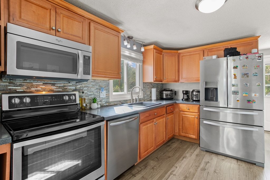70 Underhill Street Nashua, NH 03060 - Photo 10 of 39 a kitchen with stainless steel appliances granite countertop a stove a sink and a microwave