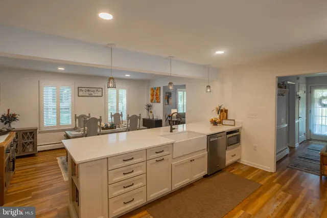 a large kitchen with kitchen island white cabinets and stainless steel appliances