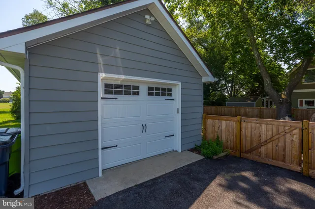 a view of backyard of house with wooden fence