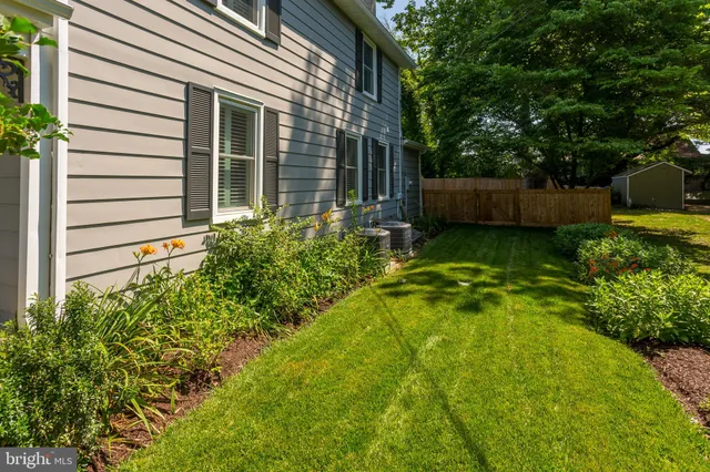 a view of a swimming pool with a lawn chairs and a large tree