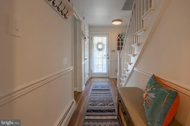 a view of a hallway with wooden floor and staircase