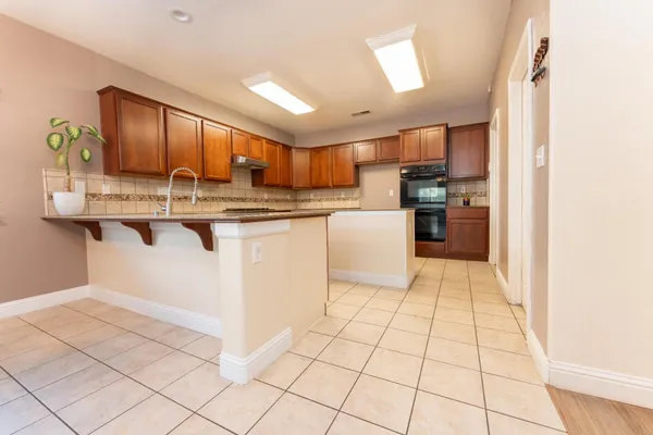a kitchen with stainless steel appliances granite countertop a stove top oven a sink a counter top space and cabinets