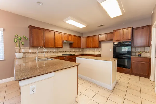 a kitchen with stainless steel appliances granite countertop a sink stove and cabinets
